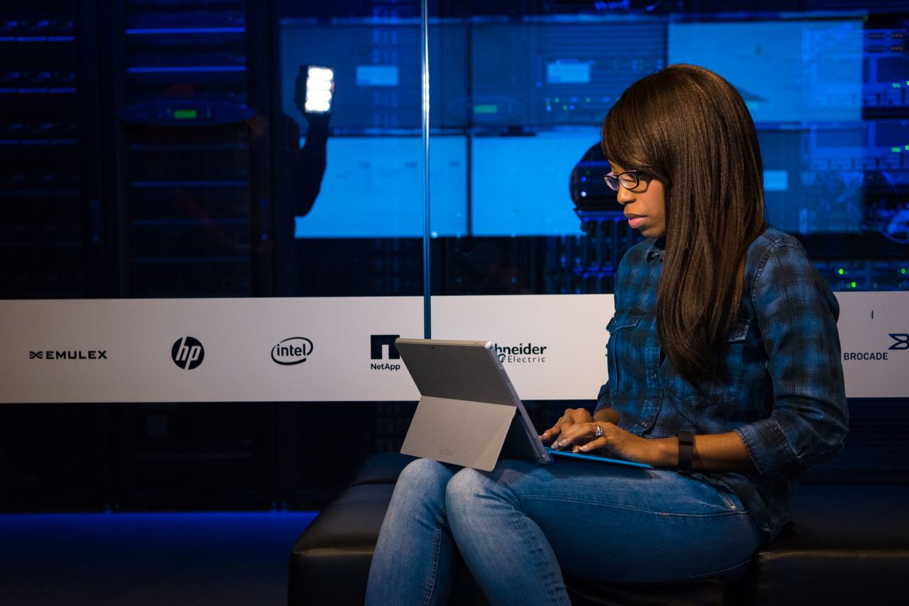 Crafting Captivating Headlines: Your awesome post title goes here Professional woman working on laptop in a server room, showcasing technology and remote work.