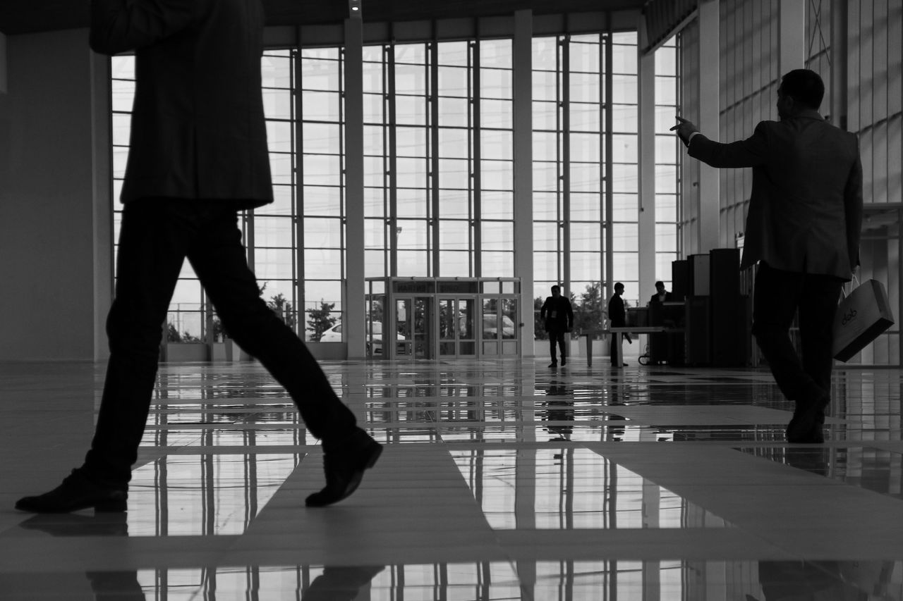 services-bg Business professionals walk through a modern, glass-paneled indoor space.