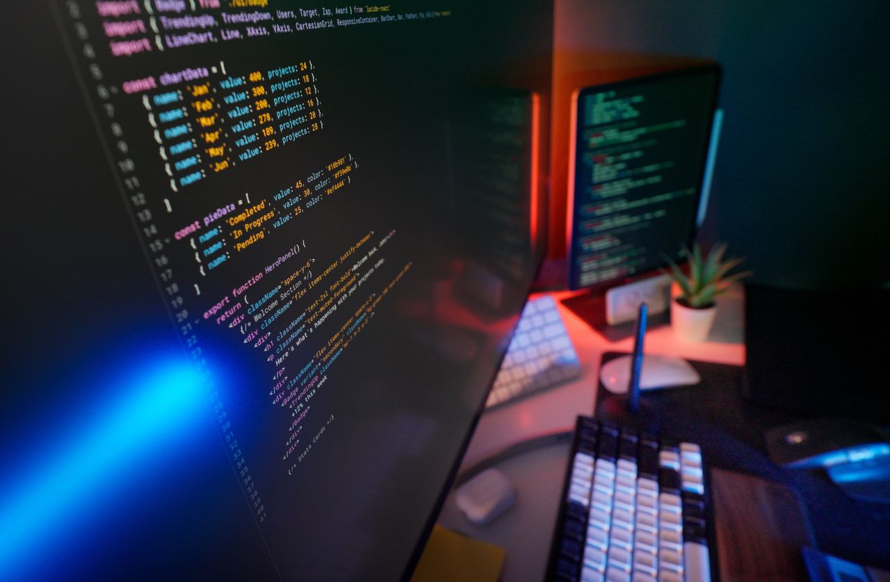 A vibrant workspace featuring colorful code on computer monitors, ideal for developers.